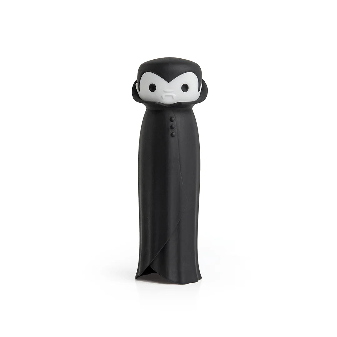 Drac N Roll cartoon vampire figure with a black cape and white face, set on a white backdrop.