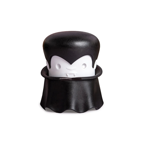 A cartoon vampire with a cape and fangs holds an OTOTO Gracula garlic crusher.